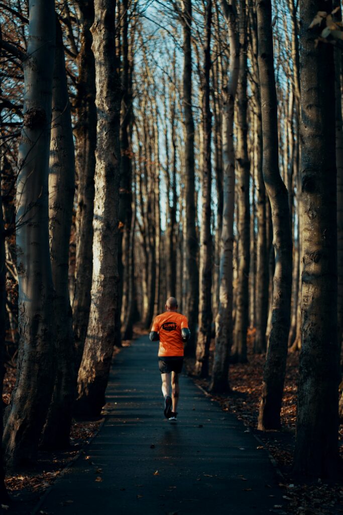 Persona che corre su un sentiero nel bosco in autunno