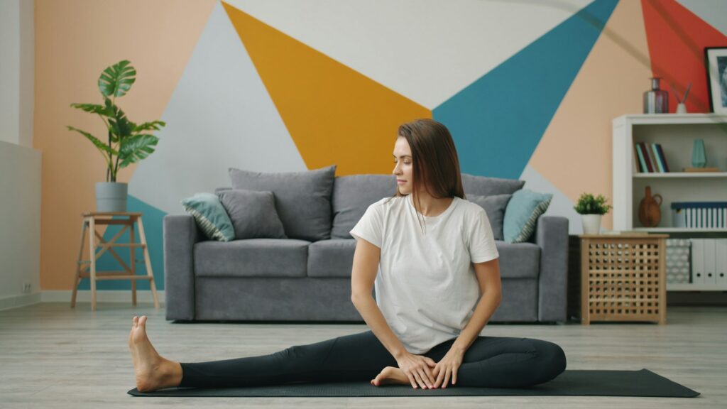 Donna che fa stretching su un tappetino in soggiorno
